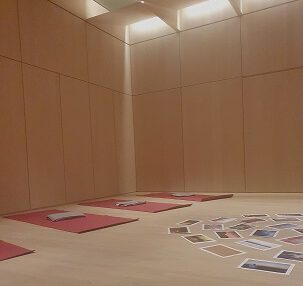 holzgetäfelter Raum mit Yogamatten und Fotos auf dem Boden